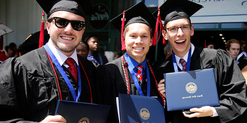男生们戴着帽子，穿着长袍，拿着毕业证书