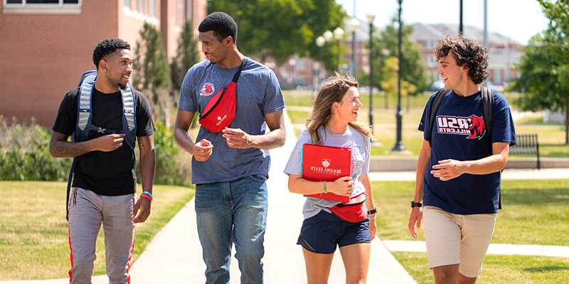 Students walking and talking on campus.