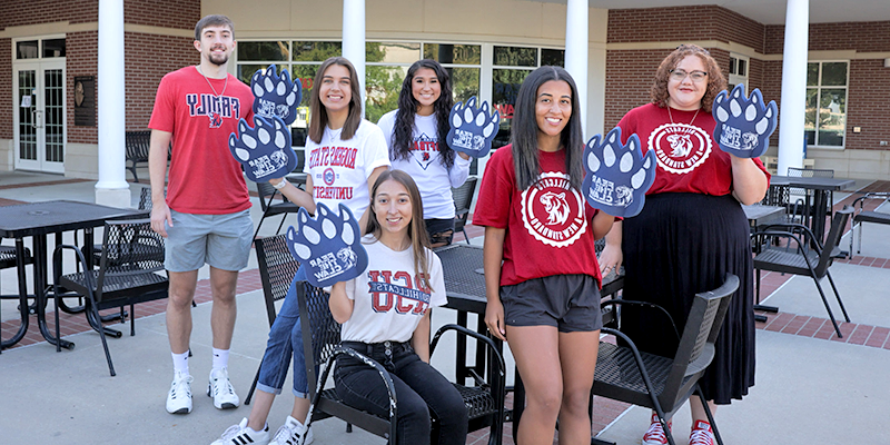 group of college students with paw foam hands